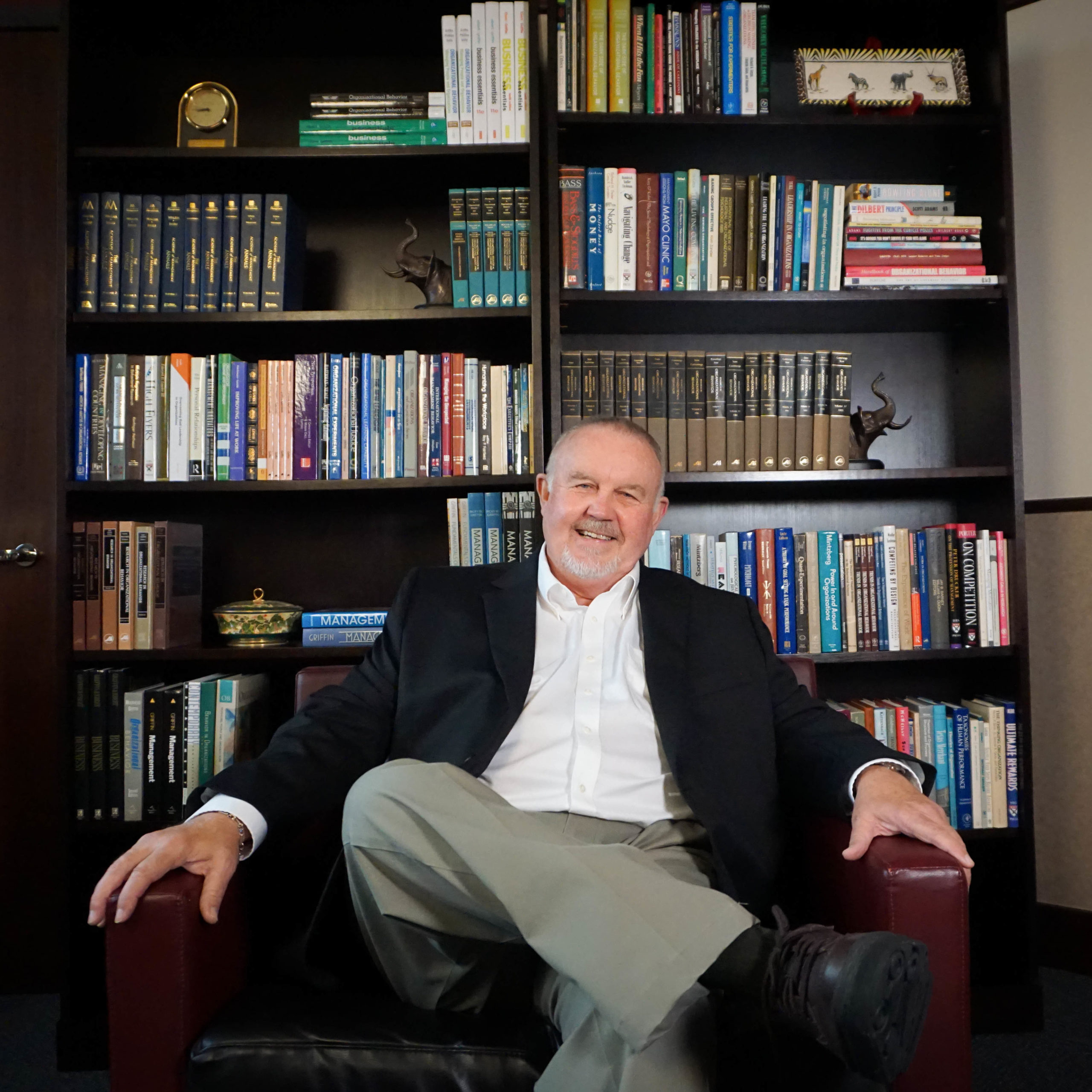 man sitting in front of bookcase