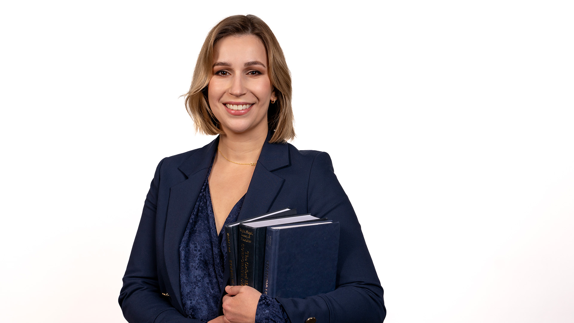 Dana Bement smiling, holding text books