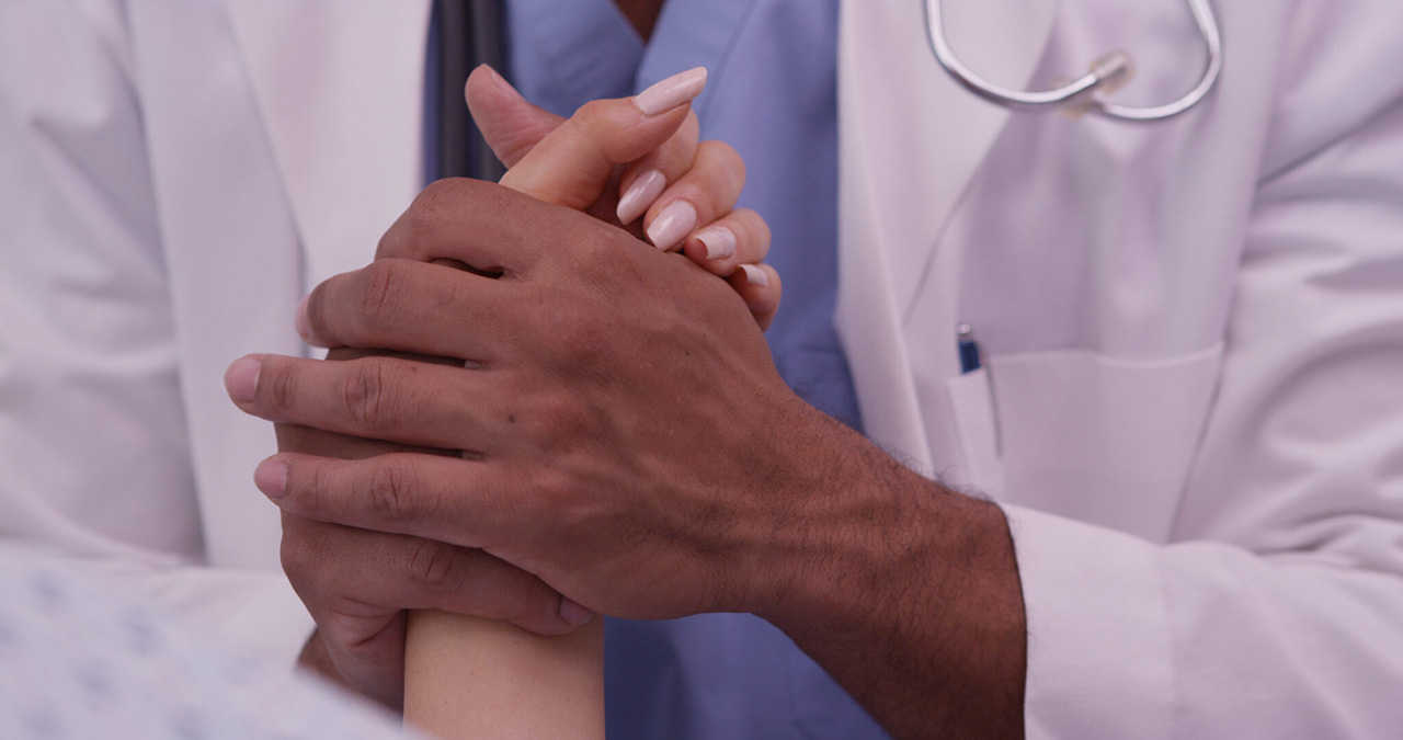 Doctor holding hands of the patient