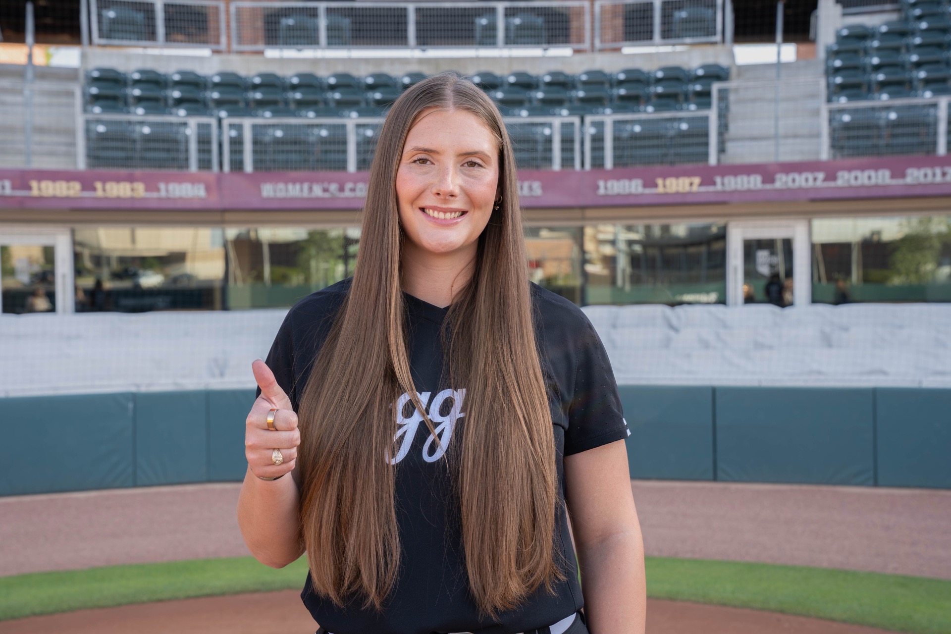 Emiley Kennedy in the softball field with Gig'em!