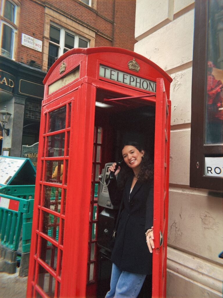 Student inside red telephone booth